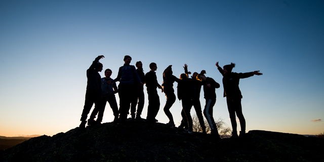 Group of people on hill at nighfall