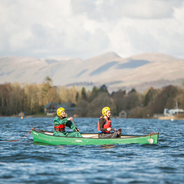 Young people canoeing on a lake