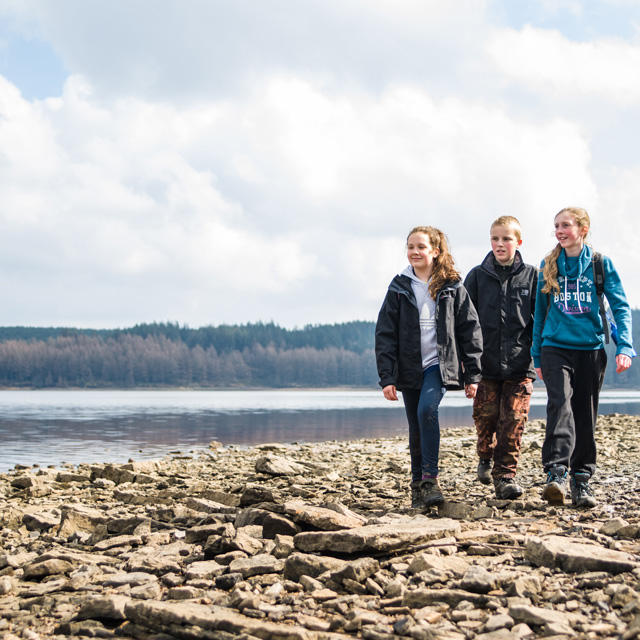 Young people walking around a lake