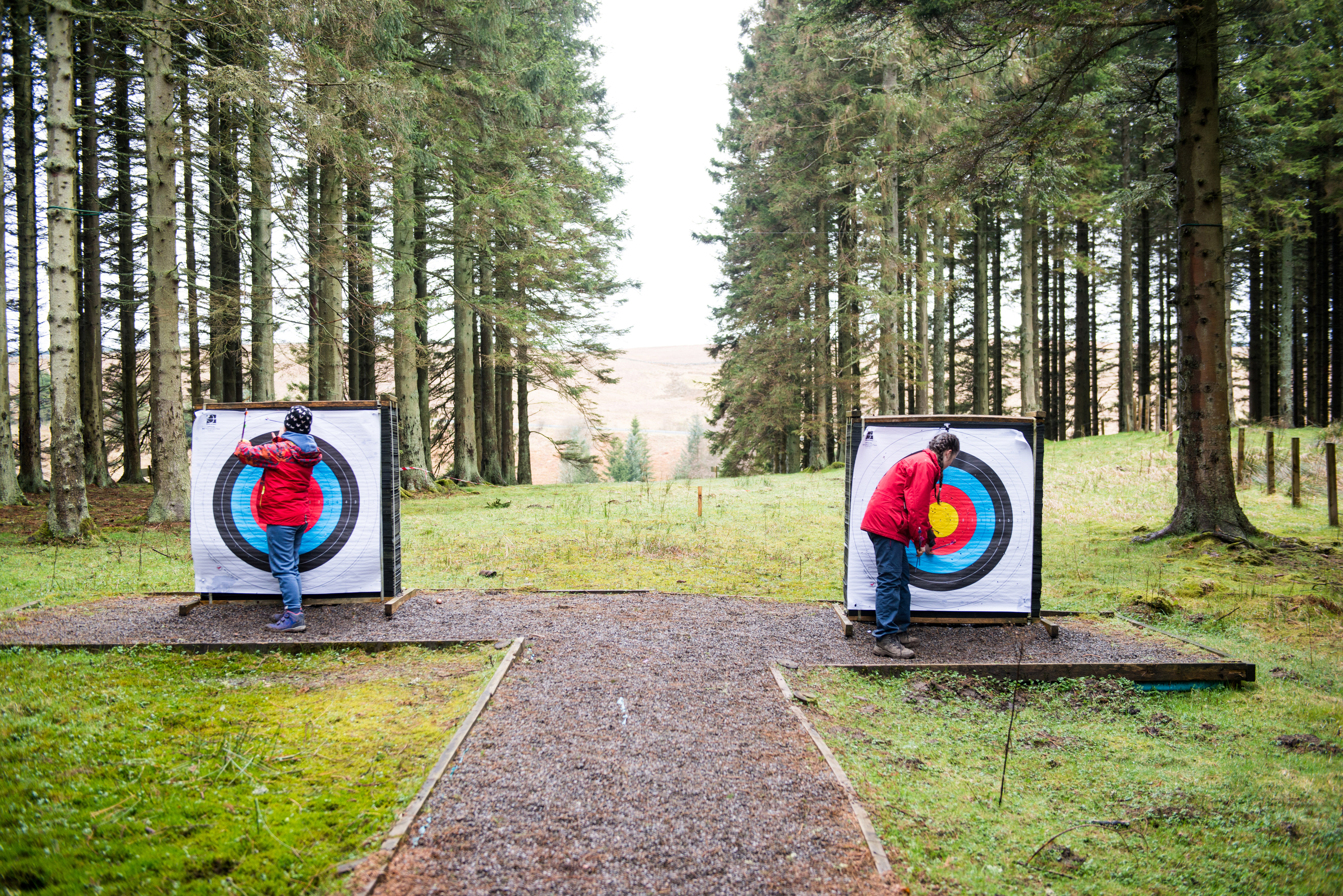 Young people on an archery range in a forest